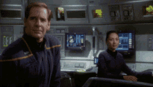 a man in a purple uniform with a yellow stripe on the sleeve stands next to a woman