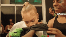 a woman wearing a green nike glove is being photographed by a man