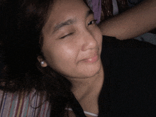 a close up of a woman 's face with her eyes closed and pearl earrings