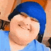 a close up of a person wearing a blue hat smiling .