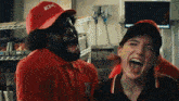 a man wearing a kfc hat and a woman wearing a kfc shirt are laughing together