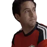 a man wearing a red shirt with a white shield on the front