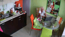a woman is sitting at a table using a laptop computer .