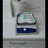 a blue and white machine with a white knob that says ' com ' on it