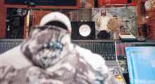 a man in a white hat is sitting in front of a mixer in a recording studio
