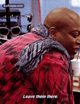 a bald man is wearing a red jacket and scarf and says `` leave them there . ''