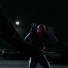 a man in a spiderman costume is kneeling down
