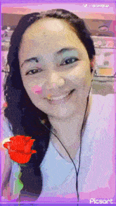 a woman is smiling with a red rose in her hand