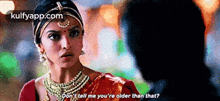 a woman in a red saree is talking to a man while wearing a turban .