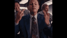 a man in a suit and tie gives the middle finger