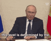 a man in a suit and tie sitting at a desk with the words " this level is determined by the " below him
