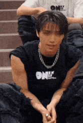 a man wearing a black shirt that says one by one