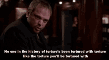 a man in a suit is talking about torture
