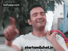 a man is laughing and holding a hula hoop with the website starttamilchat.in written on the bottom