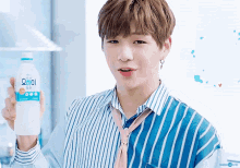 a young man is holding a bottle of water in his hand .