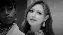 two women are standing next to each other in a black and white photo .