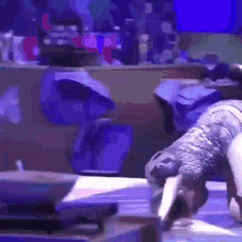 a man is doing a handstand on a table in front of a blue background .