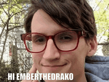 a man wearing glasses is smiling and says hi emberthedrako on the bottom