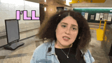 a woman with curly hair says i 'll while standing in a subway station
