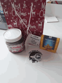 a jar of nutella is next to a christmas bag