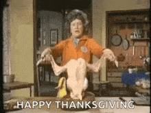 a woman is holding a dead turkey on a plate and says `` happy thanksgiving '' .