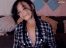 a woman in a plaid shirt is sitting on a couch with a watermark that says protected dmca