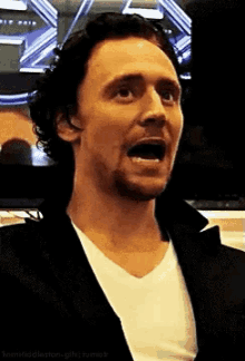 a man in a suit and white shirt is making a funny face