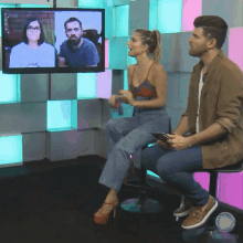 a man and a woman are sitting in front of a tv screen that says recordtv