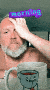 a man with a beard holds his hand to his forehead in front of a mug that says " morning "