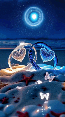 a couple of rings with hearts in them are sitting on a beach .