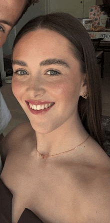 a woman wearing a necklace and earrings is smiling