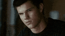 a close up of a person 's face with a black shirt on