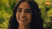 a close up of a smiling woman with a nickelodeon logo in the background