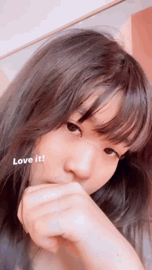 a close up of a woman covering her mouth with her hand and the words love it on the bottom