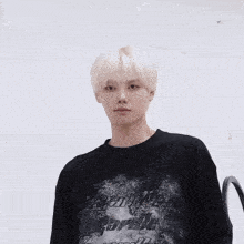 a young man with blonde hair is wearing a black t-shirt that says " really "