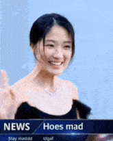 a woman in a black dress is smiling in front of a news screen that says hoes mad