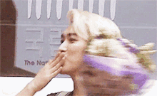 a blurry picture of a woman covering her mouth in front of a sign that says the national