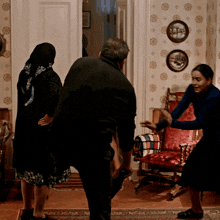 a man and two women are standing in a room