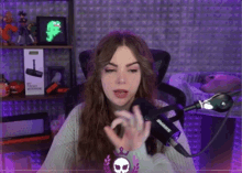a woman is sitting in front of a shure microphone in a purple room