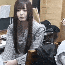 a woman with long hair is sitting in a chair in front of a computer .