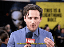 a man in a suit is holding a marvel microphone and saying " and i hope ... i did my very best "