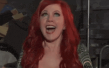 a woman with red hair and a green shirt is smiling