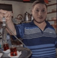 a man in a striped shirt is holding a hookah