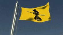 a yellow flag with a black bird and a sword on it