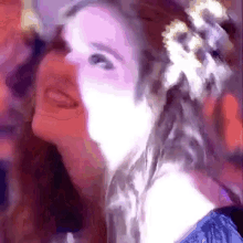 a close up of a woman 's face with a flower in her hair