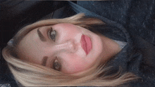 a close up of a woman 's face with a blue shirt on