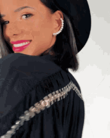 a woman wearing a black hat and a black shirt with a zipper on the back