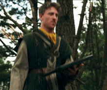 a man in a green vest is holding a gun