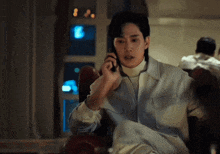 a man is sitting in a chair talking on a phone