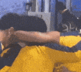 a man wearing a blue and yellow shirt with the letter t on it